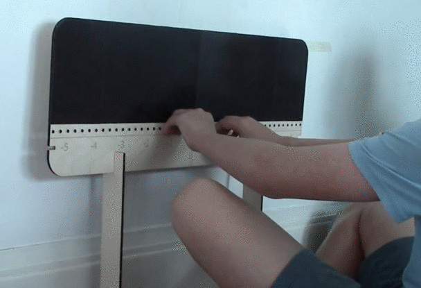 Gif of a child's hands moving over a number line. The hands move symmetrically apart away from 0 along additive inverse values, such as -1 and 1, -2 and 2. This movement maintains the balance board the child is sitting on in balance.