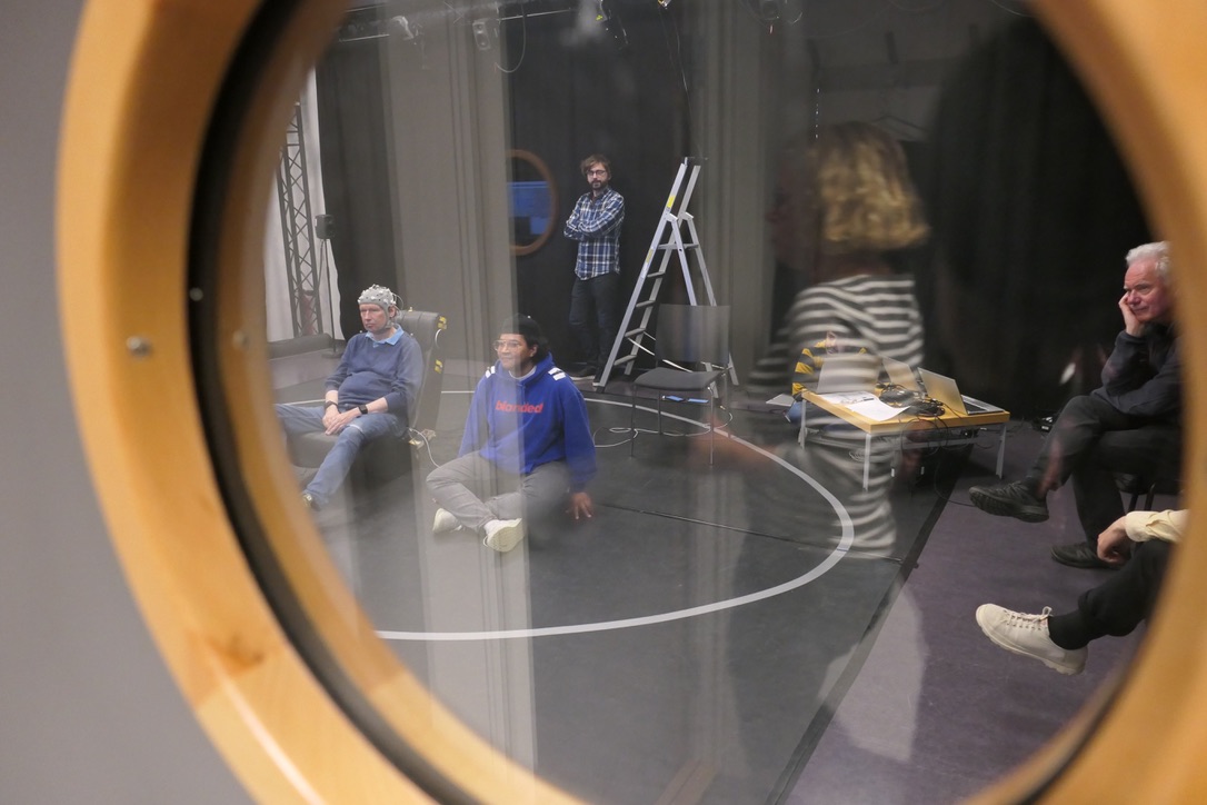 Photograph of two adults, one wearing EEG, sitting on different kinds of rockable seats and exploring Balance Board Math activities.