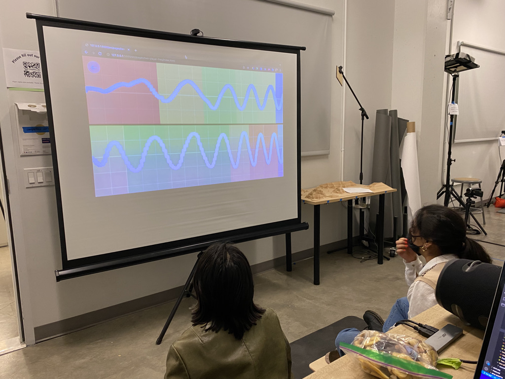 Two adult players examine colorful graphs they have just generated.