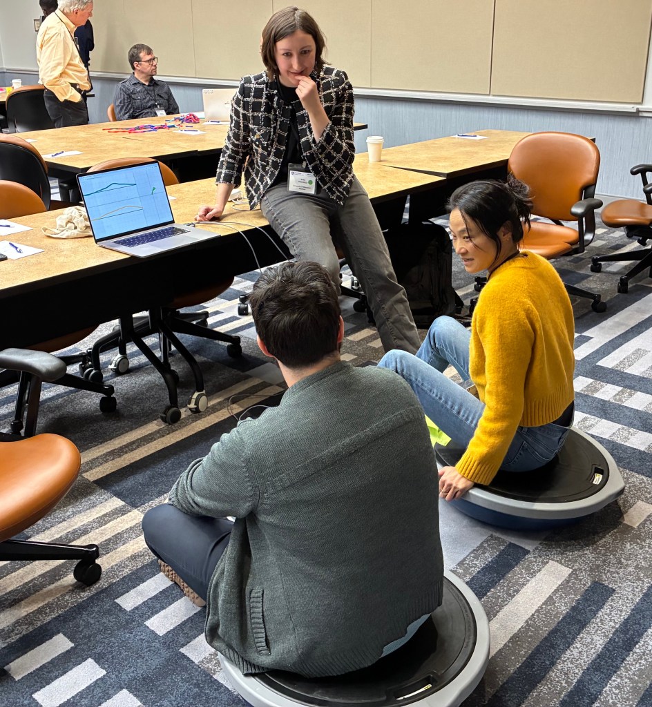 Sofia watches two researchers try to reconstruct the unit circle by generating sine and cosine functions with their rocking on upside-down bosu balls.