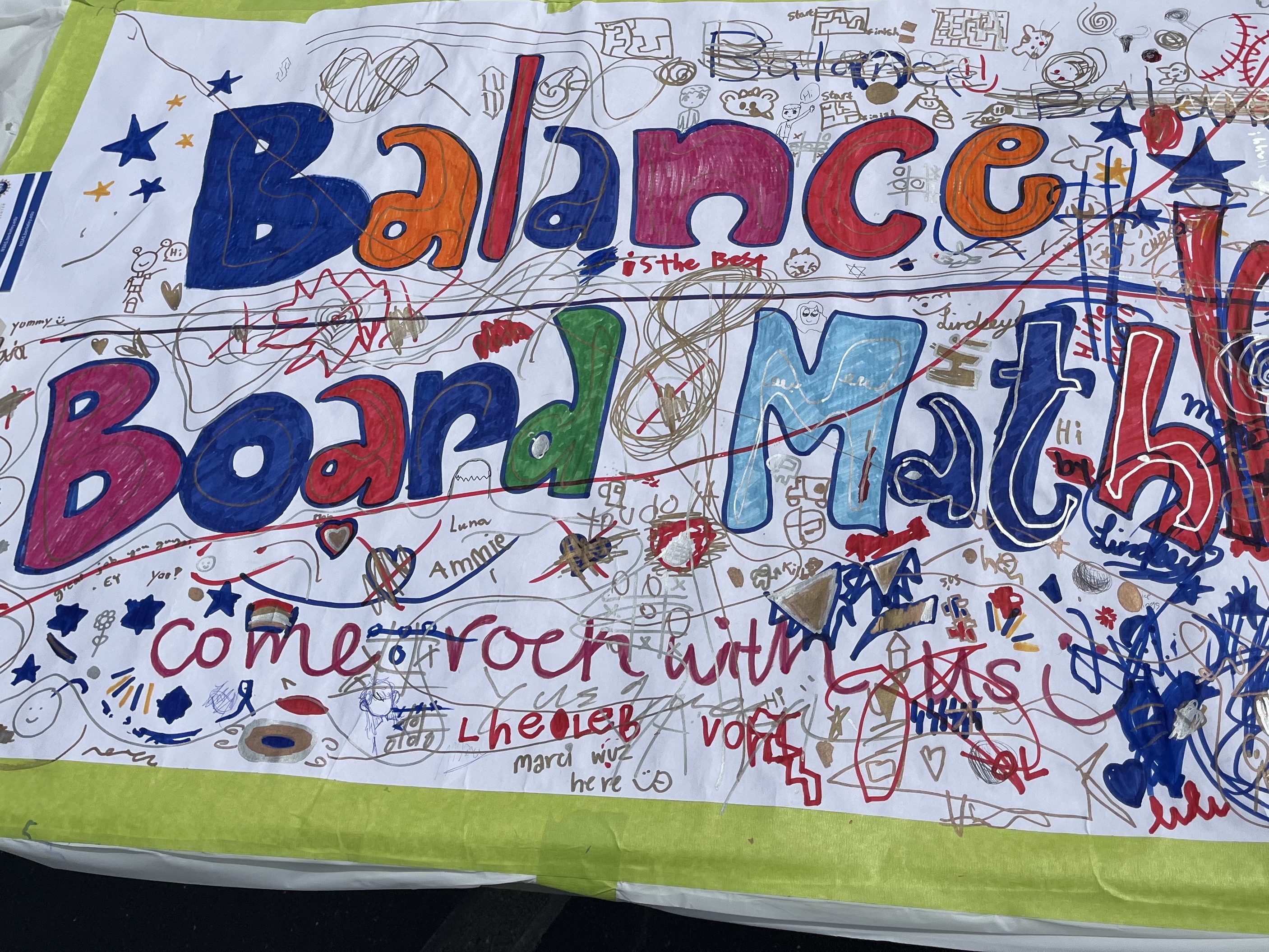 A paper sign from the Balance Board Math booth at a science fair, heavily decorated by child visitors.